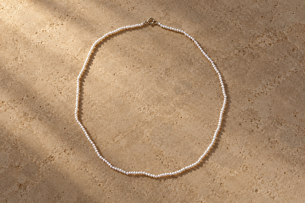 Super Small White Pearl Necklace on limestone